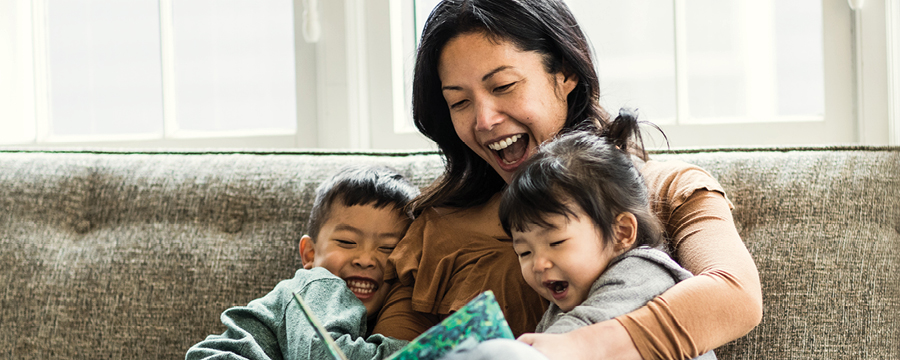 Mother reading to children on couch