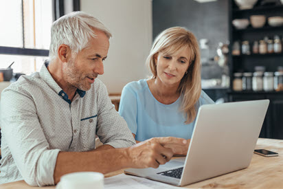 Man and woman looking at laptop together.